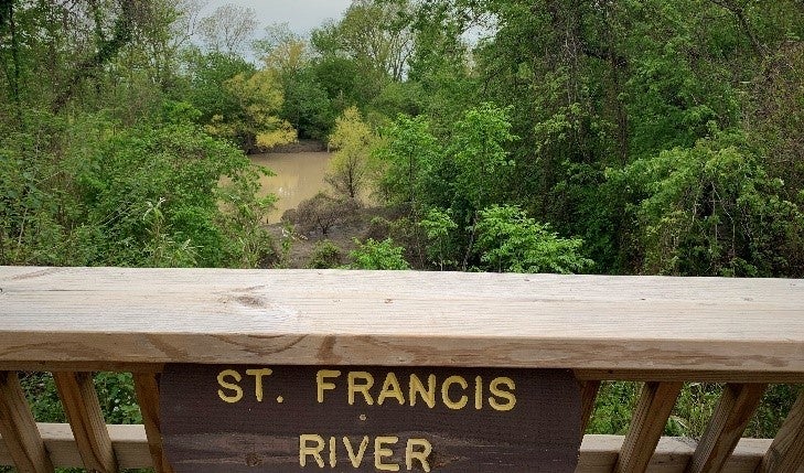 The St. Francis River surrounded by green trees as seen from the overlook along the trail at Parkin Archeological State Park. 